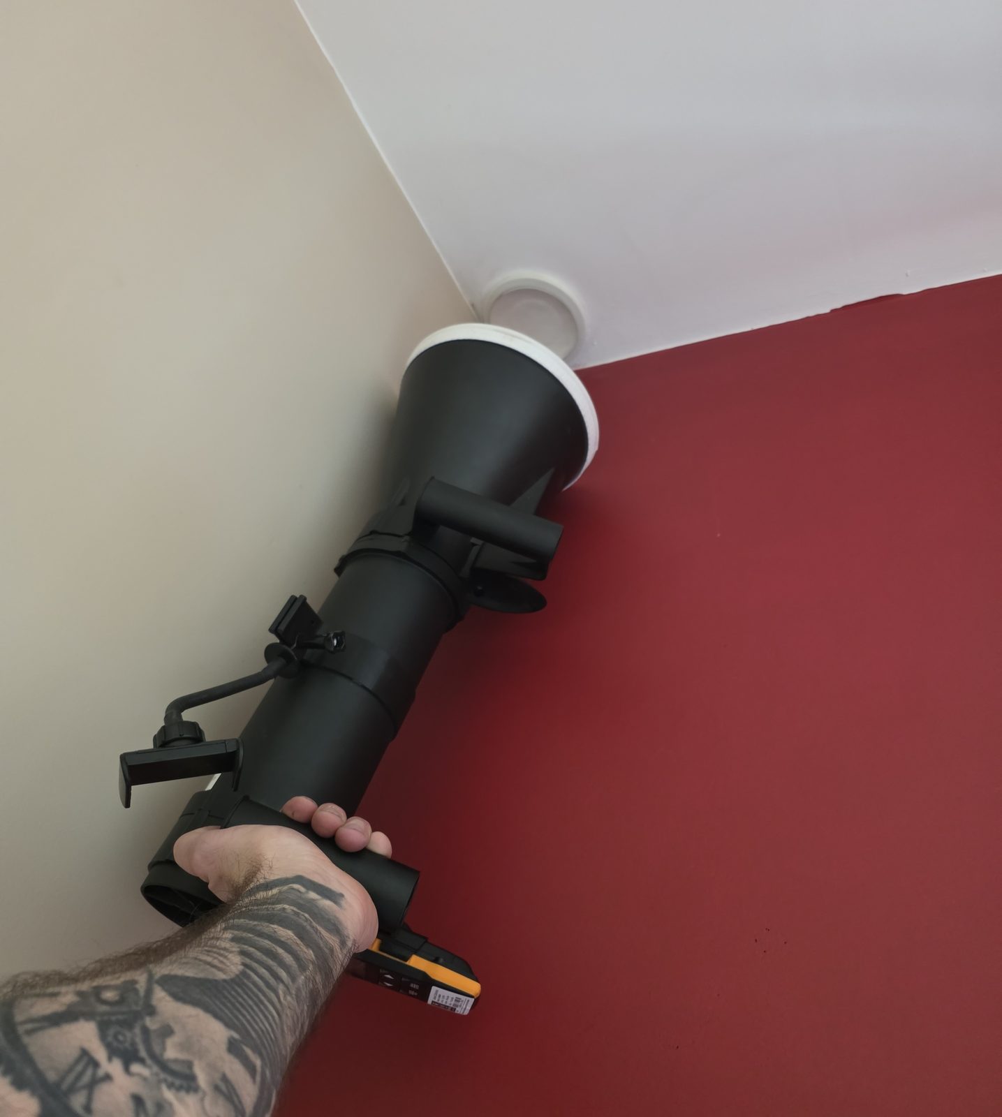 Measuring the airflow at a ceiling valve with an anemometer and hood