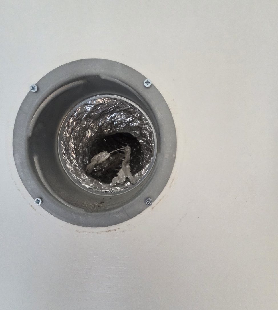 Crushed flexible duct seen through a ceiling valve opening, restricting the airflow