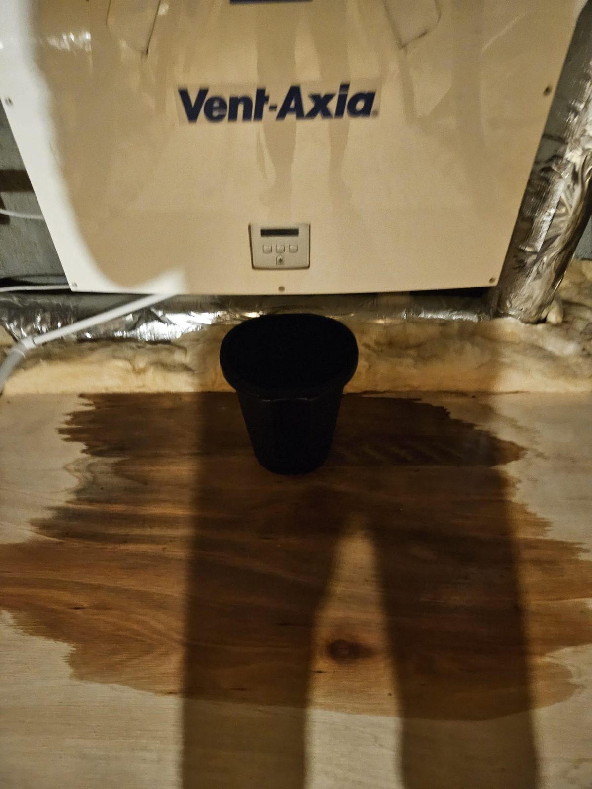Water stain on the attic floor under a Vent-Axia MVHR unit after a condensate leak