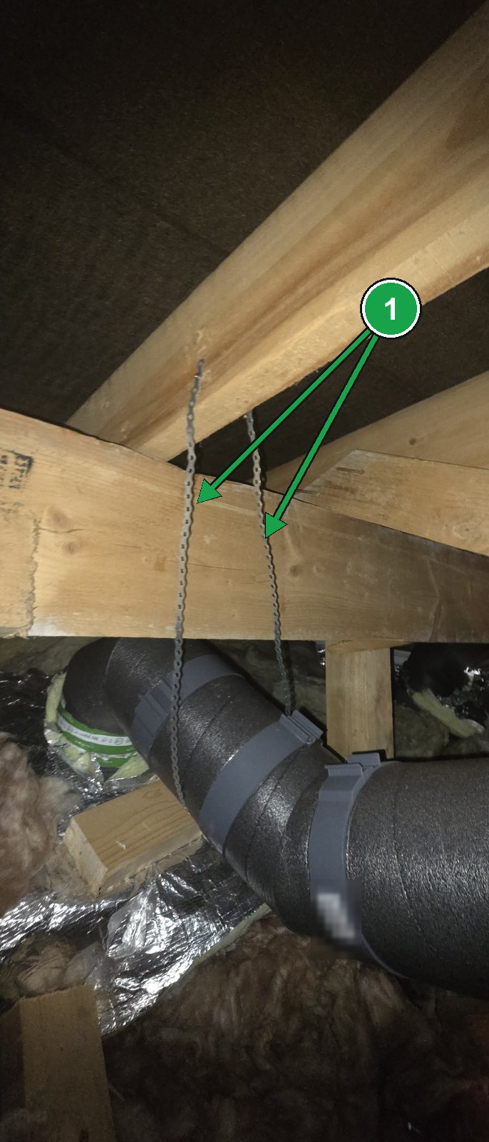 Metal hanging strap from the roof timbers holding up an MVHR duct